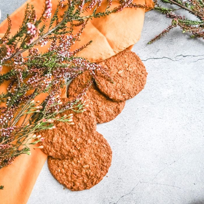 Top view of oatmeal cookies on a rustic surface with floral accents, perfect for food photography.