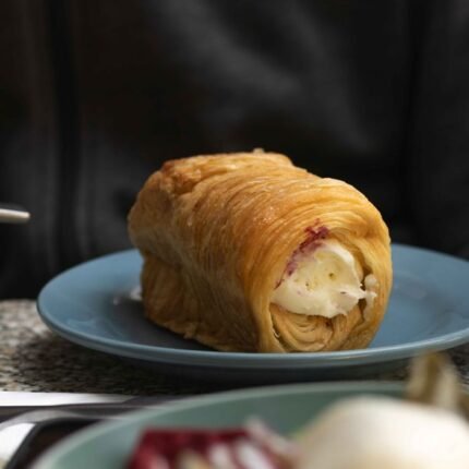 A tempting cream-filled pastry on a blue plate, perfect for dessert lovers.
