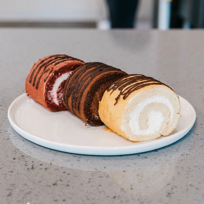 A delightful assortment of rolled cakes showcasing chocolate, vanilla, and red velvet flavors, perfect for dessert lovers.