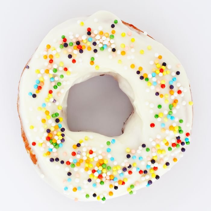 Delicious donut with colorful sprinkles and white icing, perfect for dessert lovers.