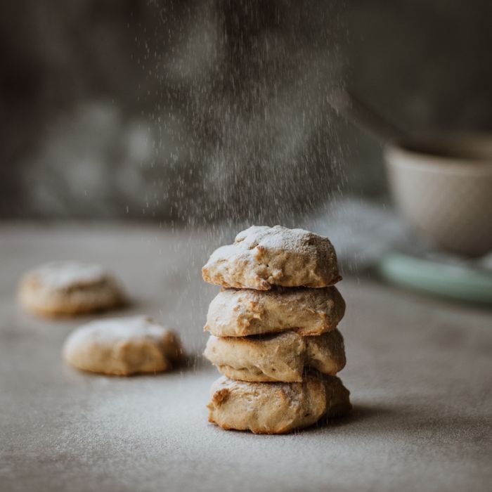 Stack of delicious homemade cookies with powdered sugar, perfect for snacking and baking inspiration.