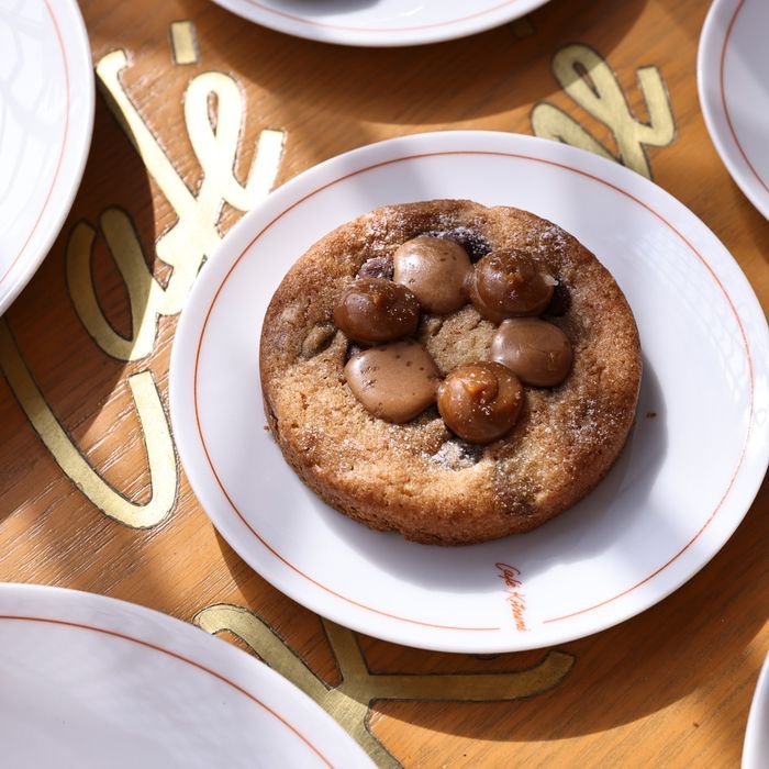 Delicious gourmet chocolate chip cookie on a café-branded plate.