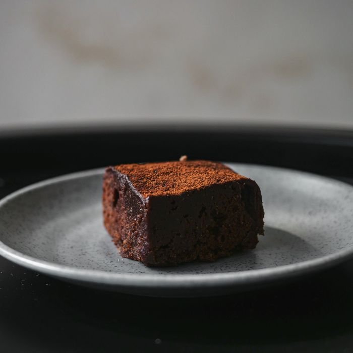 Close-up of a decadent chocolate brownie on a speckled gray plate.
