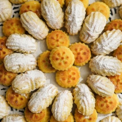 A top-down view of golden-brown cookies adorned with powdered sugar, arranged appealingly.