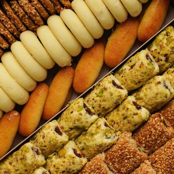 Flat lay of assorted Middle Eastern pastries featuring pistachios, sesame seeds, and more.