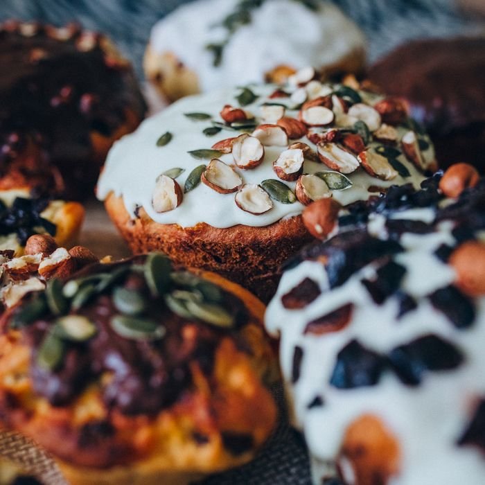 Close-up view of freshly baked muffins with assorted toppings and glaze, perfect for food lovers.